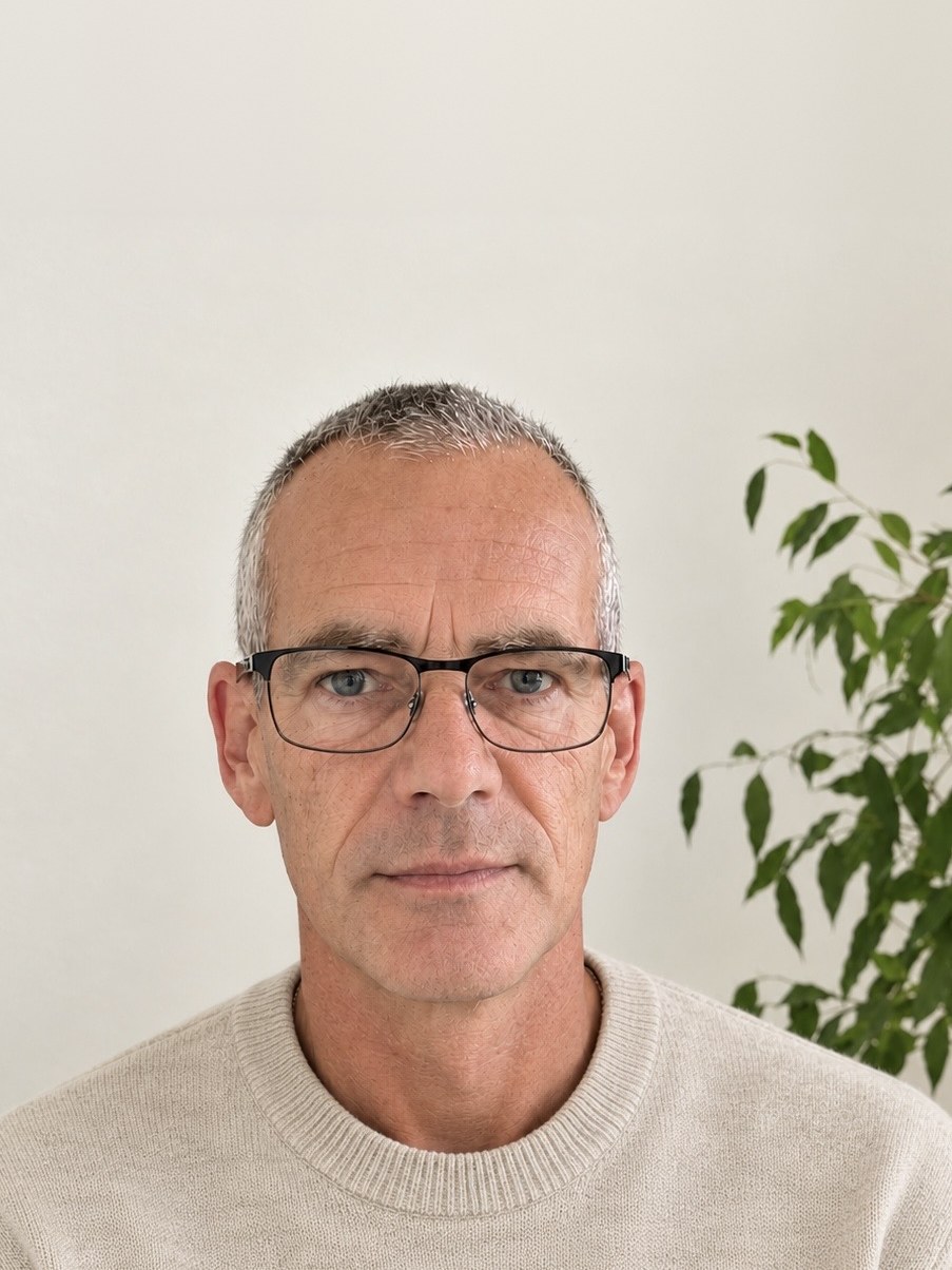 Stefan Münch mit Brille vor einer Zimmerpflanze